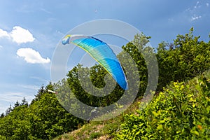 The man losing control during the start with the paraglider, the parachute bowl lies on the tree.