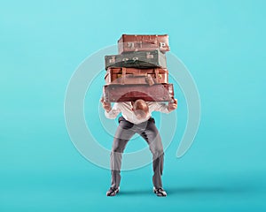 Man with a lot of luggages is exhausted and stressed to travel