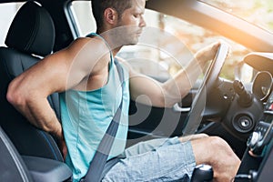 Man with back pain after a long drive in car