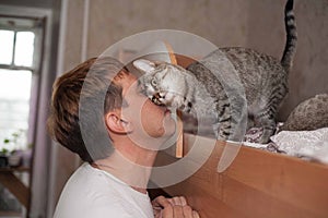 A man loves his cat, a cat responds to a person in return.