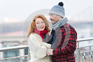 Man loves rude woman closing his eyes. Guy in rad jacket and scurf happy to woman in red scurf. Aged couple meet in city.