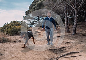 Man lovingly playing with his rottweiler dog