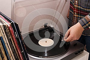 man lowers the tonearm on a vinyl record