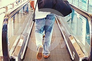 A man with luggage on a horizontal escalator