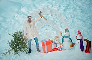 Man lumberman with Christmas tree in winter park. Winter emotion. Man is going to cut a Christmas tree. Hipster woodsman