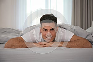 Man lying in bed with grey linens