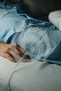 man lying in bed wearing a urinary catheterization