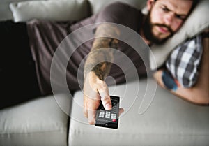 Man lying on a couch watching tv