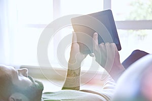 Man lying with digital tablet pc at home