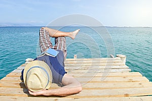 Man lying on the dock with a book