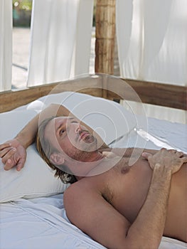 Man Lying In Four-Poster Bed