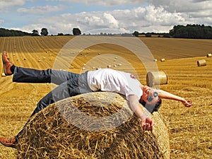 Man lying on hay bale