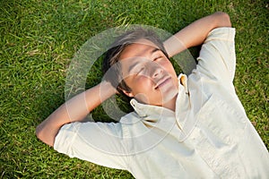 Man lying with his eyes closed and both hands behind his neck