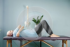 A man lying on the massage table in constructive rest postion