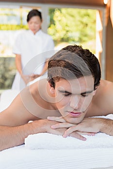 Man lying on massage table at spa center