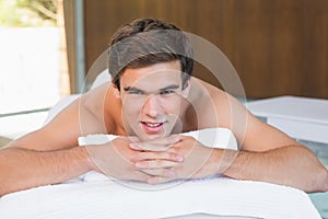 Man lying on massage table at spa center