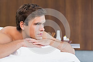 Man lying on massage table at spa center