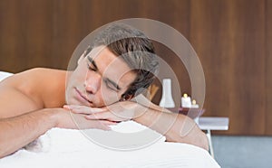 Man lying on massage table at spa center