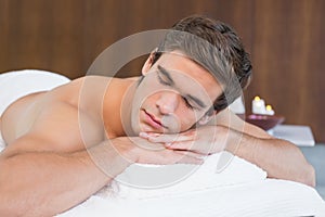 Man lying on massage table at spa center