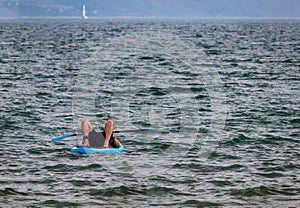 Man lying on a paddle board at Weymouth beach front