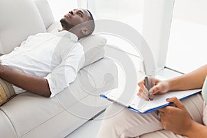 Man lying on sofa talking to his therapist