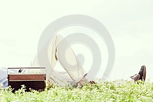 Low section of man lying by vintage radio on grass against clear sky photo