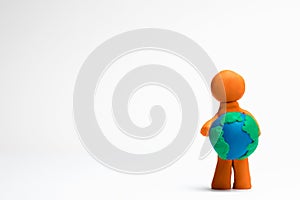 A man made of plasticine holding a model of planet earth on white background, aligned to the right