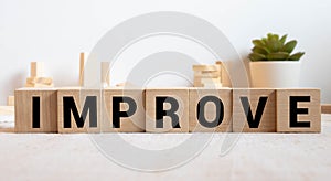 Man made word IMPROVE with wood blocks
