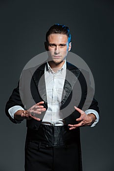 Man magician in balck tail coat conjuring tricks photo