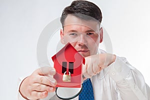 Man with a magnifying glass and paper house