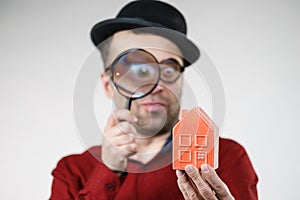 Man magnifying red house