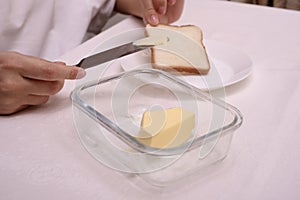 man makes a breakfast sandwich from white bread with butter