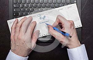 Man makes calendar entry tax declaration photo
