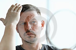 Man makes his hair with gel closeup