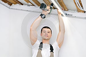 Man makes home repairs. Preparing to install a stretch ceiling