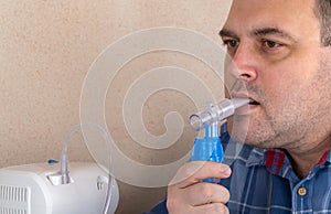 Man makes inhalations with the help of nebulizer. patient breathes through an Oxygen Mask. device for nebulization of a medicinal