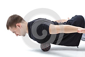 A man makes strengthening exercises for the body with special sports equipment. Self massage increases the body`s tone