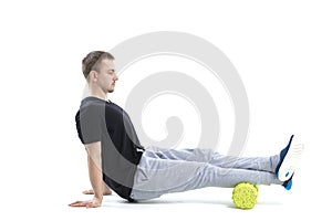 A man makes strengthening exercises for the body with special sports equipment. Self massage increases the body`s tone