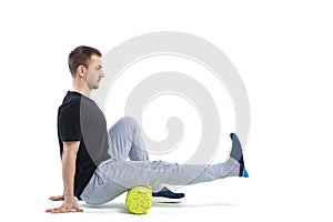 A man makes strengthening exercises for the body with special sports equipment. Self massage increases the body`s tone