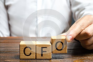 A man makes the word acronym abbreviation CFO. Chief Financial Officer. Financial management in business and company