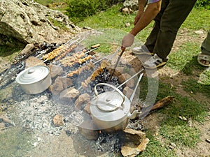 A man making barbecue outdoors in the park in mountain.