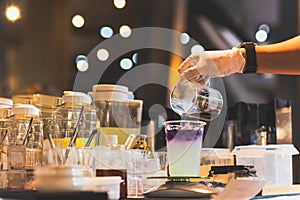 Man making butterfly tea with yuzu juice in a tak away glasses.