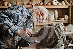 Man making ceramic sculpture on wheel