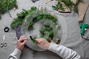 Man making Christmas wreath. New year holiday decoration photo