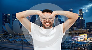 Man making finger glasses over city background