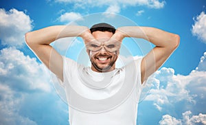 Man making finger glasses over sky background
