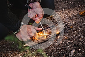 Man making fire with tinder polypore fungus in a forest