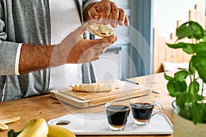 Man making healthy breakfast or brunch, putting banana slices on puffed corn cakes with spread peanut butter. Protein diet healthy