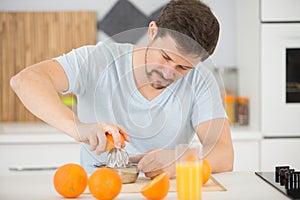 man making healthy organic orange juice