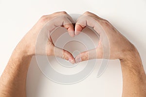 Man making heart with his hands on white background